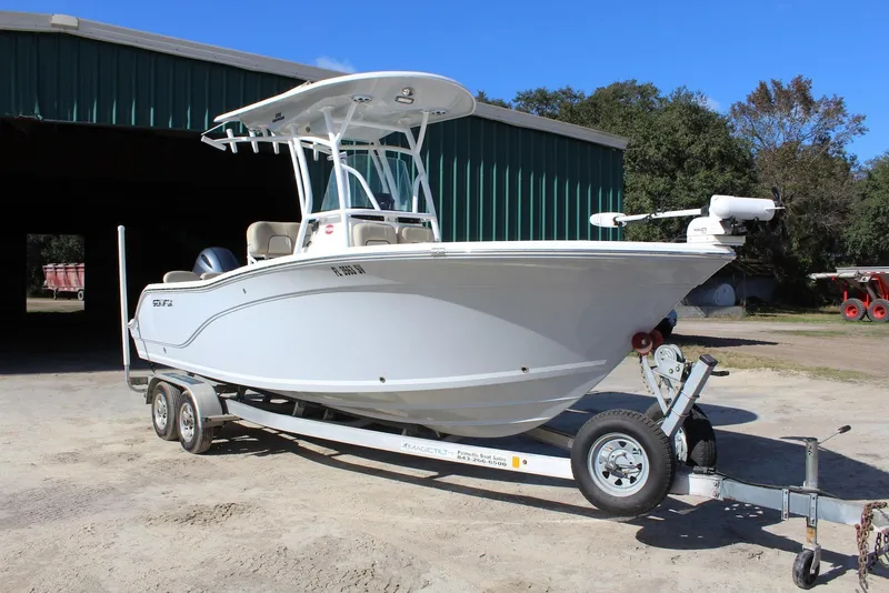 Slide: The Image of 2018 Sea Fox 226 Commander boat on trailer, parked outside a green building. - 6