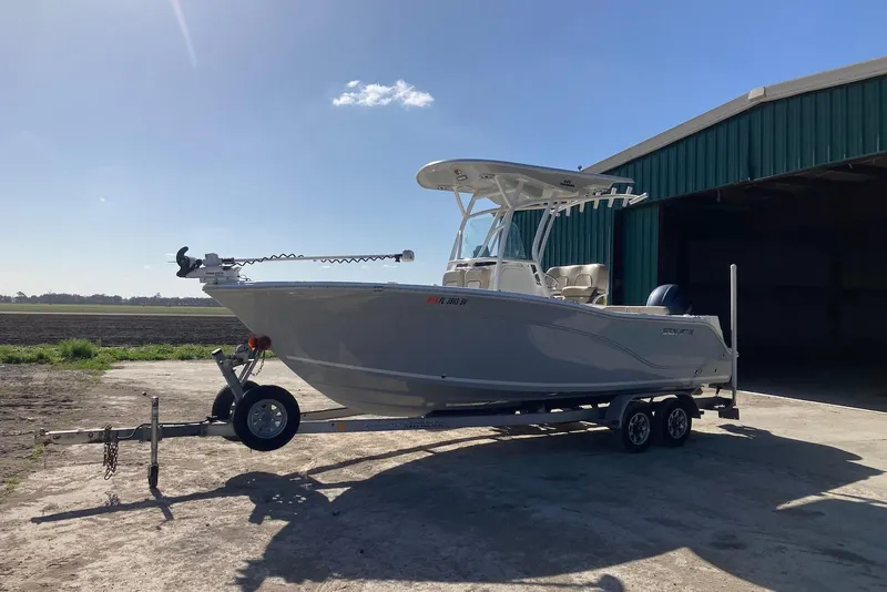 Slide: The Image of 2018 Sea Fox 226 Commander boat on trailer, parked near a large green building. - 8