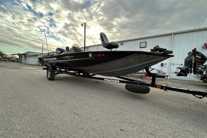 The Image of 2014 Bass Tracker PRO TEAM 175 TXW boat on trailer by a lake. - 0