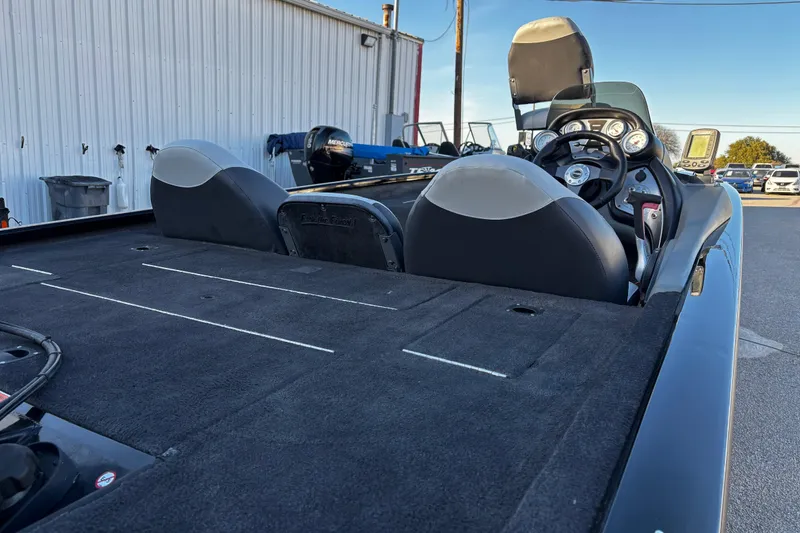 Slide: The Image of 2014 Bass Tracker PRO TEAM 175 TXW boat interior with Mercury engine by the water. - 24