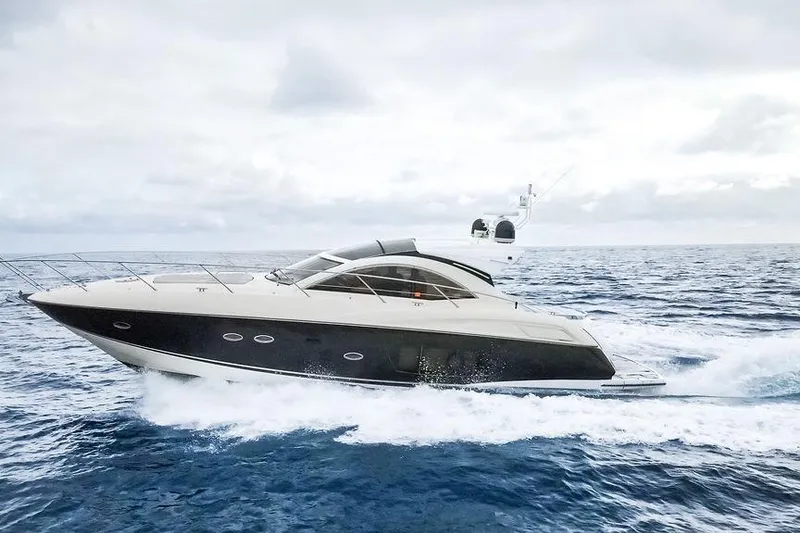 The Image of 2013 Sunseeker Portofino yacht cruising on open sea under cloudy skies. - 0