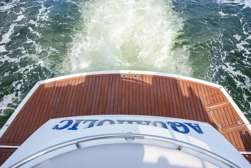 Slide: The Image of Rear view of 2013 Sunseeker Portafino yacht with wooden deck on water. - 10