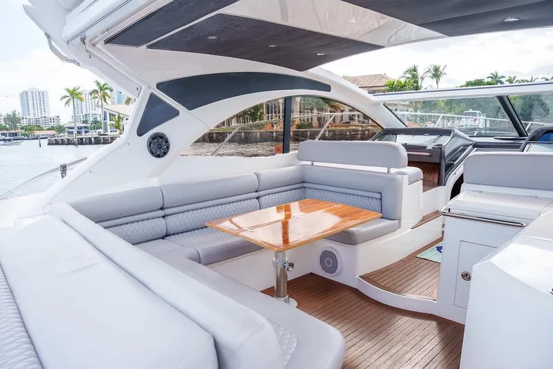 Slide: The Image of Luxurious 2013 Sunseeker Portafino yacht interior with elegant seating and wooden table by the water. - 29