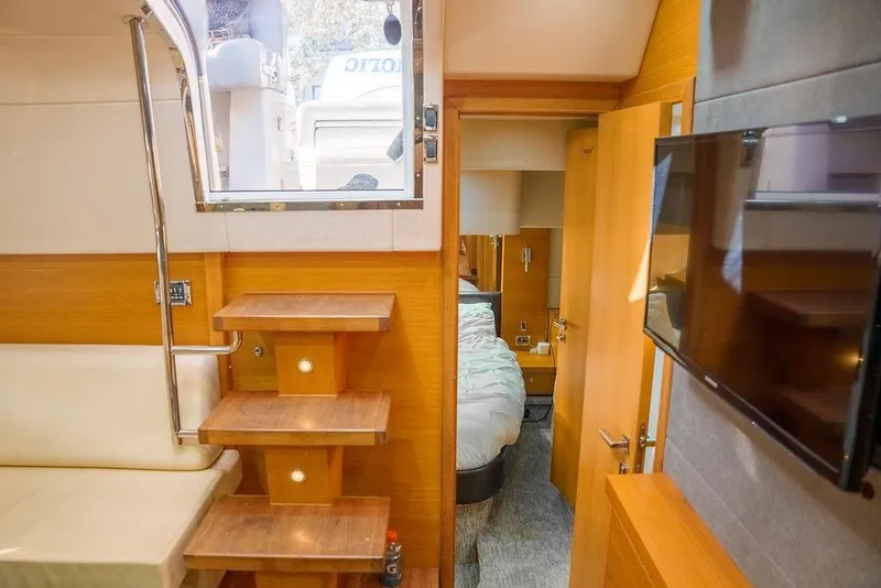 Slide: The Image of 2013 Sunseeker Portafino yacht interior with beige seating and wooden cabinetry. - 62