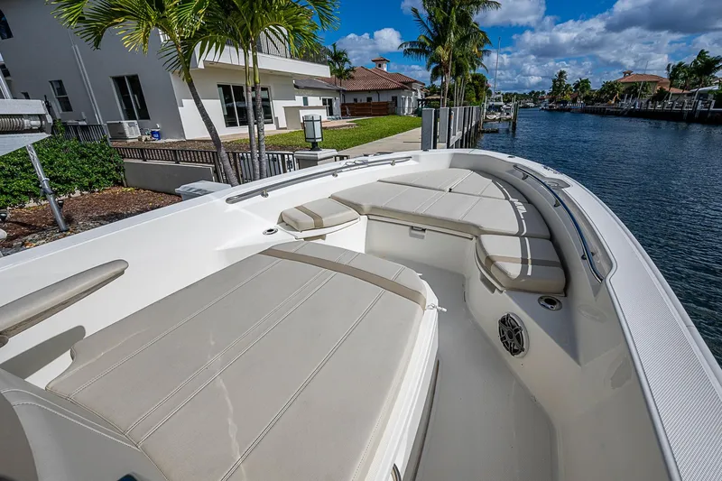 Slide: The Image of 2023 Boston Whaler 250 Dauntless boat interior with cushioned seating by waterfront. - 1