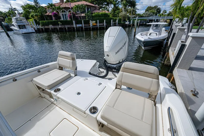 Slide: The Image of 2023 Boston Whaler 250 Dauntless boat with Mercury engine docked by waterfront homes. - 11