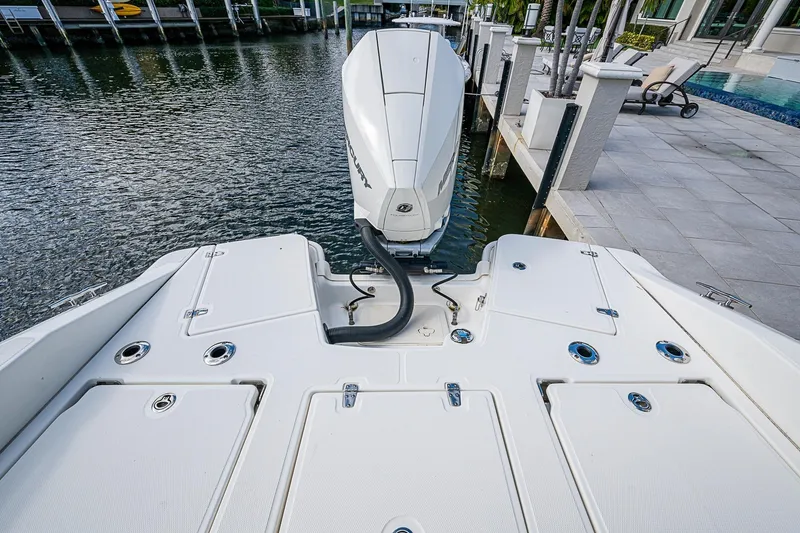 Slide: The Image of 2023 Boston Whaler 250 Dauntless boat docked, showcasing rear deck and outboard motor. - 20