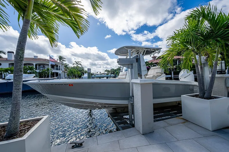 Slide: The Image of 2023 Boston Whaler 250 Dauntless boat docked by waterfront, surrounded by palm trees. - 21