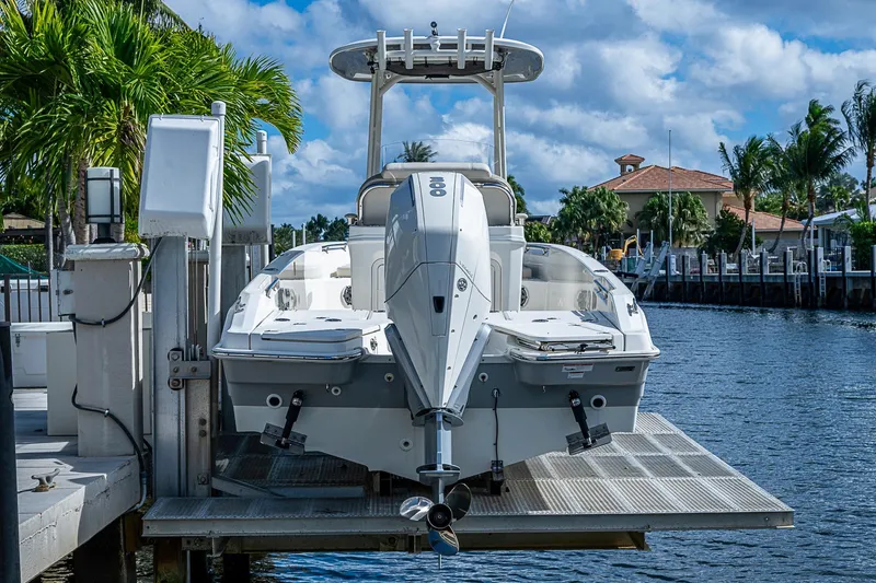 Slide: The Image of 2023 Boston Whaler 250 Dauntless boat docked by a scenic waterfront. - 22