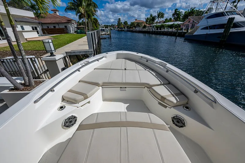 Slide: The Image of 2023 Boston Whaler 250 Dauntless boat interior with cushioned seating and waterfront view. - 3