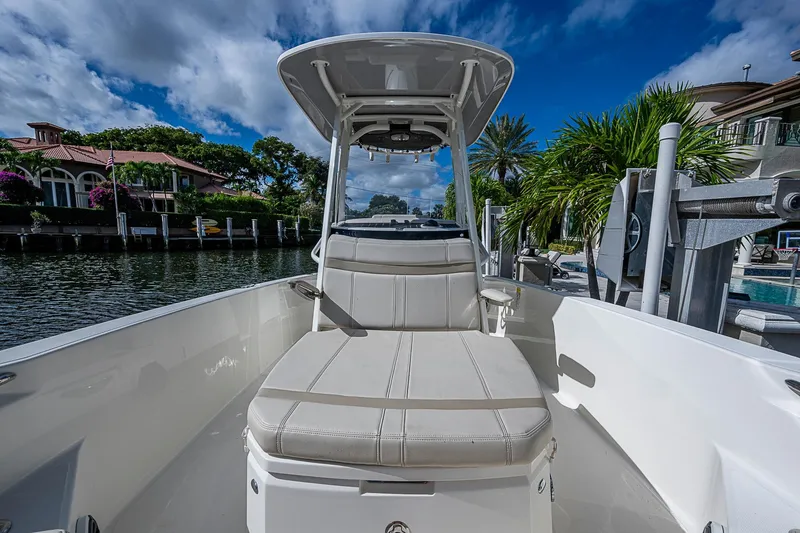 Slide: The Image of 2023 Boston Whaler 250 Dauntless boat interior with seating, docked by waterfront homes. - 7