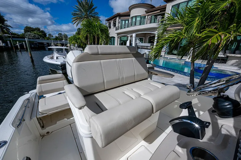 Slide: The Image of 2023 Boston Whaler 250 Dauntless boat with luxurious seating, docked near waterfront property. - 9