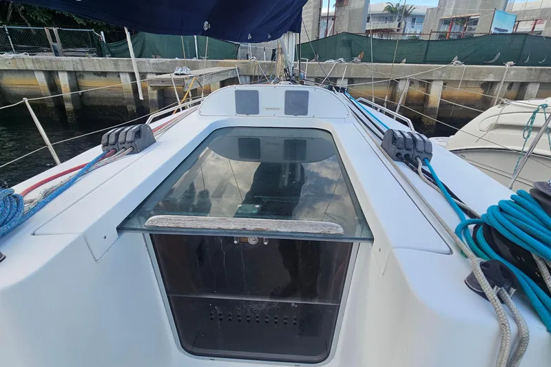 Slide: The Image of 2004 Beneteau First 36.7 sailboat deck with ropes and hatch, docked at marina. - 10