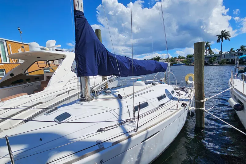 Slide: The Image of 2004 Beneteau First 36.7 sailboat docked, blue sail cover, sunny day, waterfront view. - 2