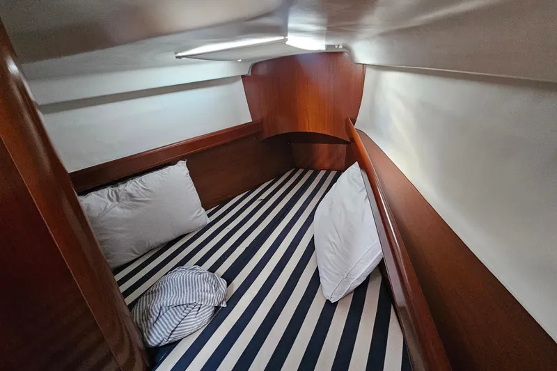 Slide: The Image of Cozy cabin interior of 2004 Beneteau First 36.7 sailboat with striped bedding. - 20
