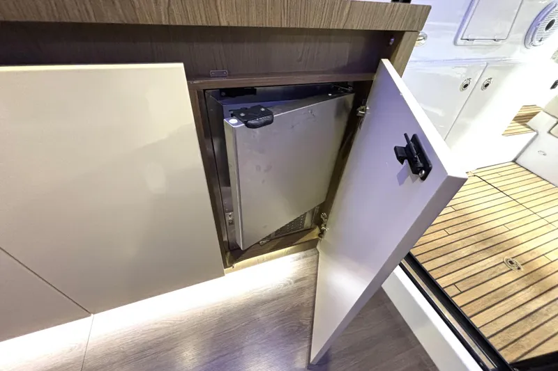 Slide: The Image of 2015 Beneteau Gran Turismo 49 yacht interior with open cabinet and mini fridge. - 16