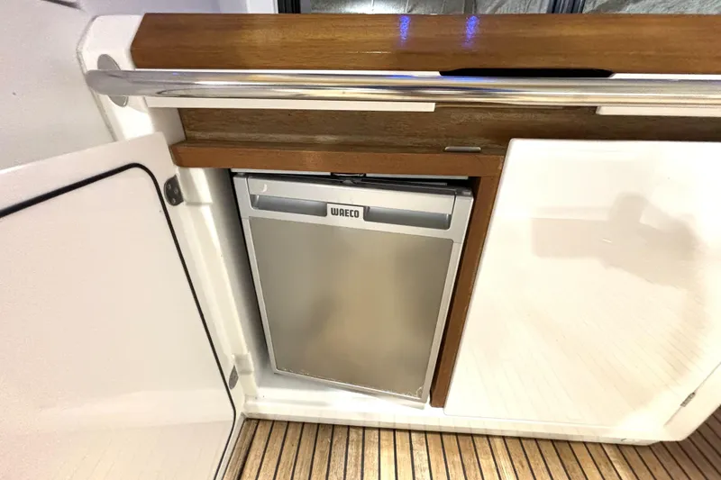 Slide: The Image of Compact fridge on 2015 Beneteau Gran Turismo 49 yacht, featuring sleek wood and metal design. - 17