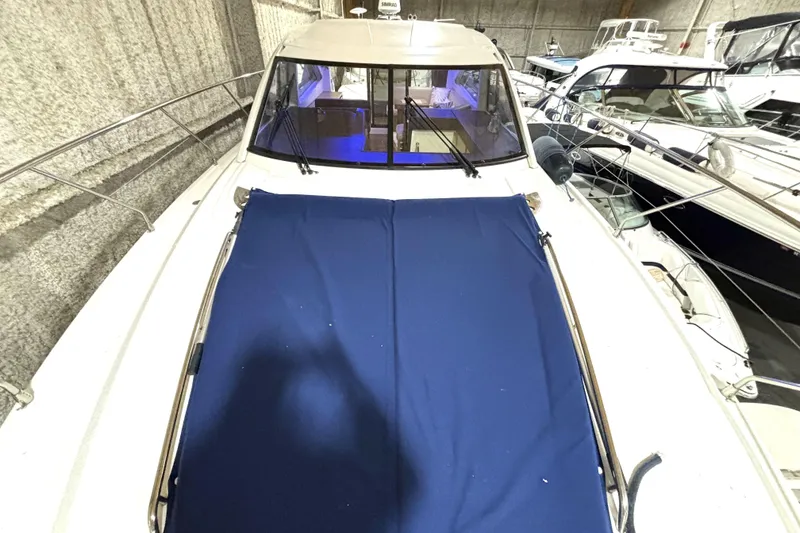Slide: The Image of 2015 Beneteau Gran Turismo 49 yacht with blue cover, docked indoors. - 27