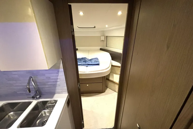 Slide: The Image of Interior of 2015 Beneteau Gran Turismo 49 yacht, featuring a cozy bedroom and kitchenette. - 42