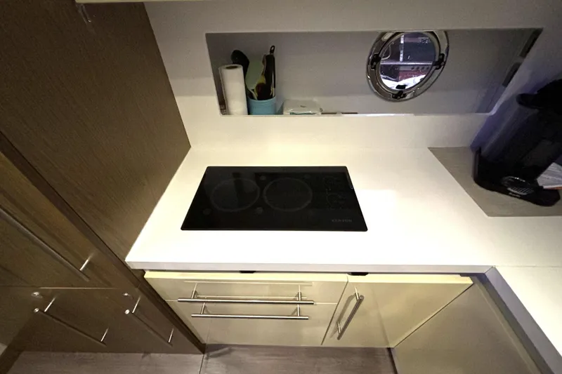 Slide: The Image of Modern kitchen in 2015 Beneteau Gran Turismo 49 yacht with stovetop and porthole. - 49
