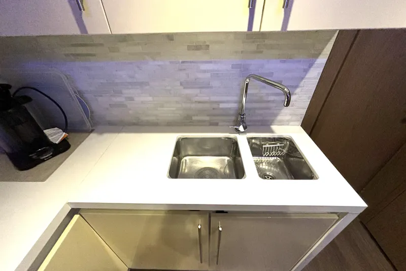 Slide: The Image of Modern kitchen sink area on 2015 Beneteau Gran Turismo 49 yacht, featuring dual sinks and sleek faucet. - 50