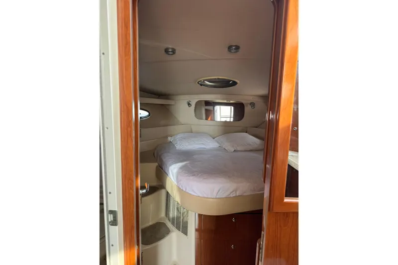 Slide: The Image of 2005 Regal Commodore 3880 cabin interior with cozy bed and wooden accents. - 17