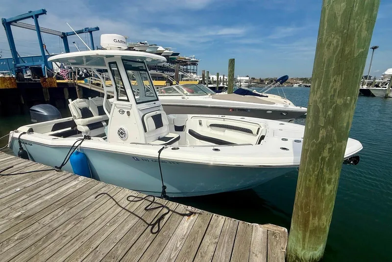 Slide: The Image of 2024 Tidewater 232 LXF boat docked at marina under clear blue sky. - 1