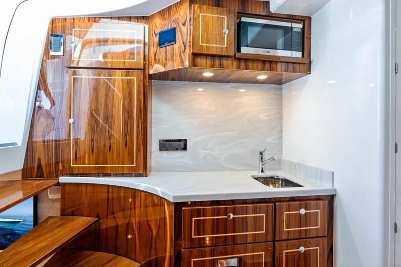 Slide: The Image of Luxurious 2025 HCB 56 Suenos GIX yacht interior with elegant wood cabinetry and modern kitchenette. - 19