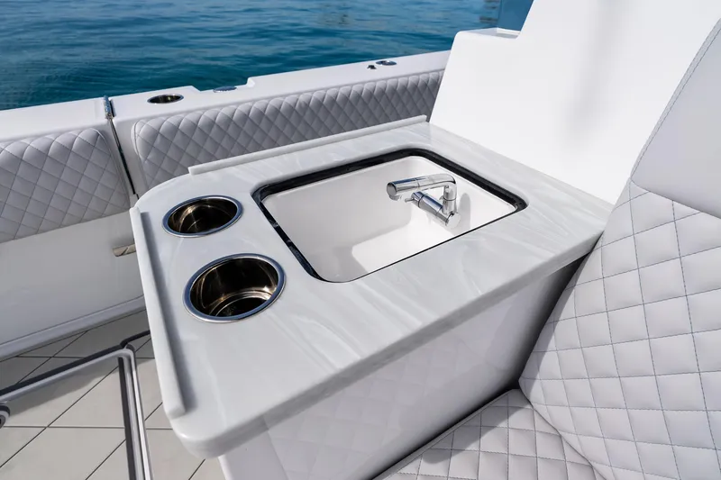 Slide: The Image of Luxury seating and sink on 2025 HCB 56 Suenos GIX yacht, featuring quilted upholstery. - 56