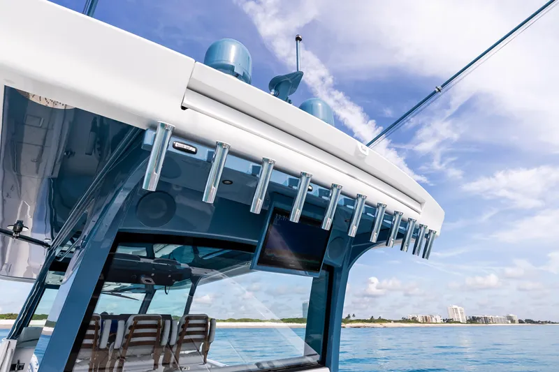 Slide: The Image of 2025 HCB 56 Suenos GIX boat, sleek design, ocean backdrop, clear sky. - 24