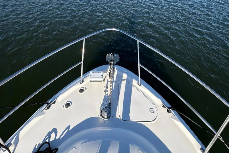 Slide: The Image of Bow view of 1999 Sea Ray 380 Sundancer yacht on calm water. - 16