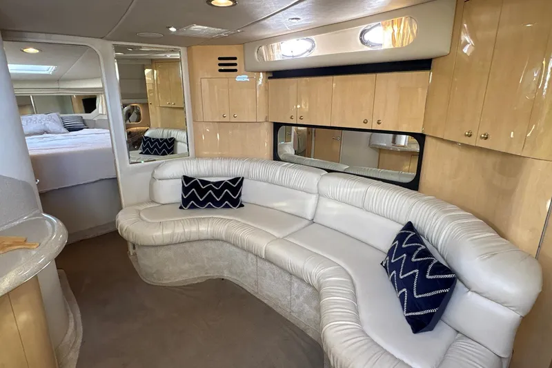 Slide: The Image of Luxurious interior of 1999 Sea Ray 380 Sundancer with white leather seating and wooden cabinetry. - 18