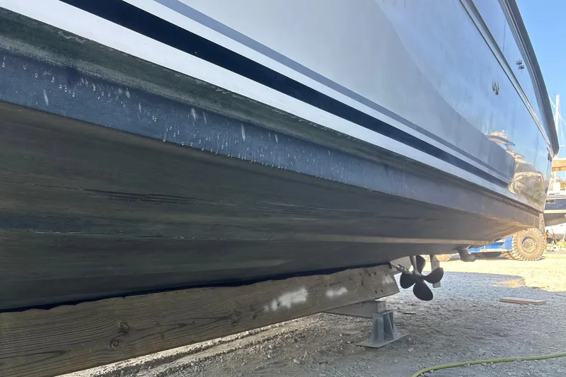 Slide: The Image of 1999 Sea Ray 380 Sundancer boat hull on dry dock, showing propeller and support structure. - 22