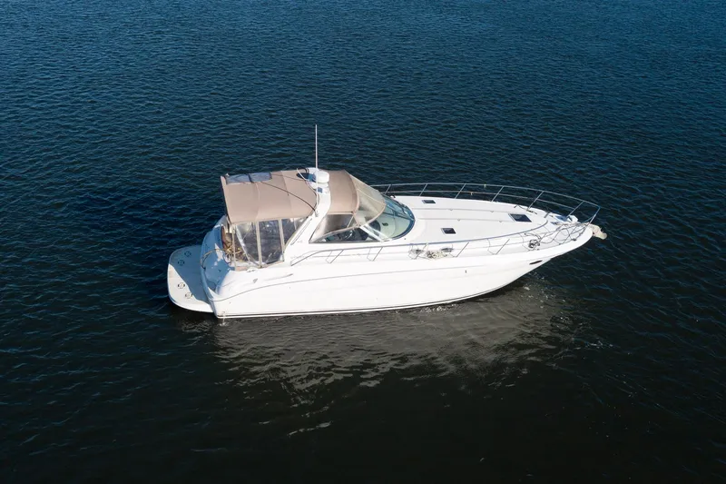 Slide: The Image of 1999 Sea Ray 380 Sundancer yacht cruising on open water. - 31