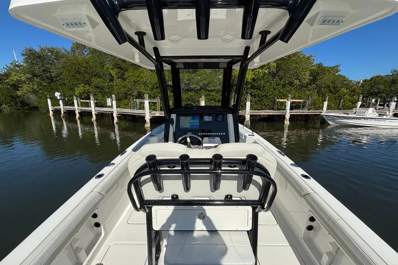 Slide: The Image of 2026 World Cat 235 TE boat interior, featuring helm and seating, docked by a serene waterfront. - 9