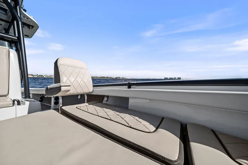 Slide: The Image of 2021 Barker Boatworks 26 Open interior with beige seating, ocean view in background. - 24