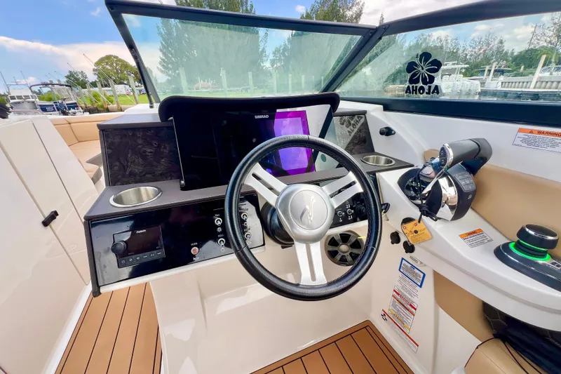 Slide: The Image of 2019 Sea Ray SDX 290 Outboard boat interior with modern helm and beige seating. - 16