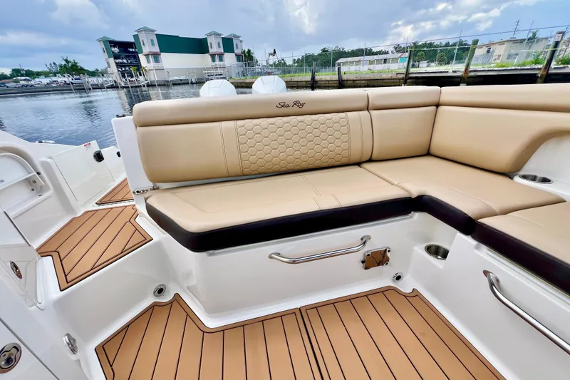 Slide: The Image of 2019 Sea Ray SDX 290 Outboard boat interior with tan seating and waterfront view. - 7