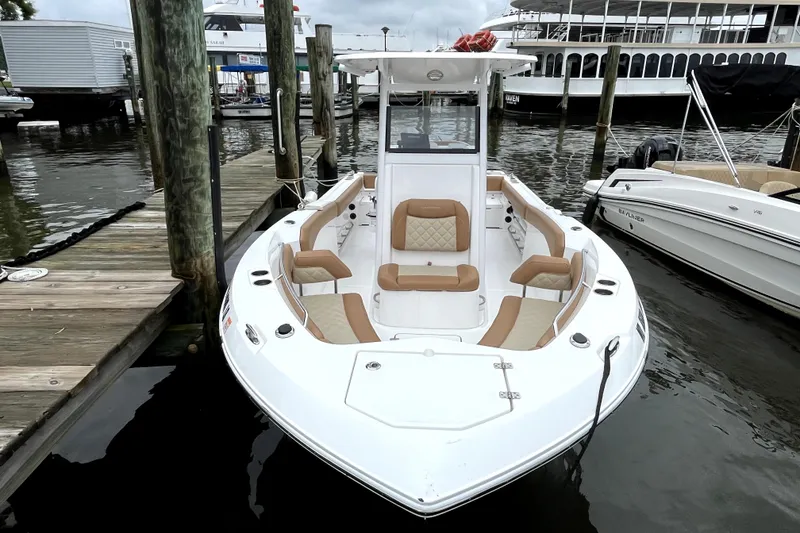 Slide: The Image of 2025 NauticStar 242L Offshore boat docked, featuring spacious seating and sleek design. - 1