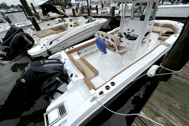 Slide: The Image of 2025 NauticStar 242L Offshore boat docked, featuring dual Mercury engines and spacious seating. - 2