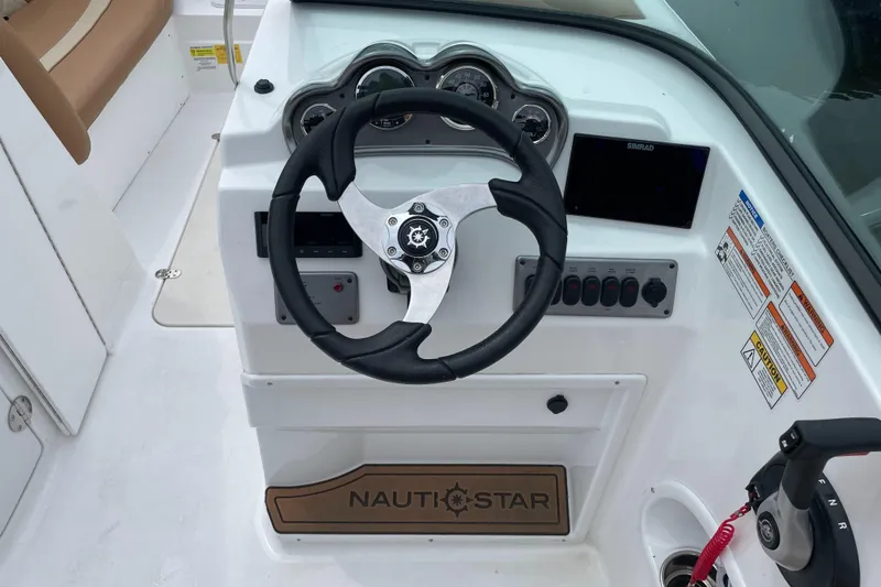 Slide: The Image of 2025 NauticStar 223 DC Deck boat steering console with gauges and controls. - 3