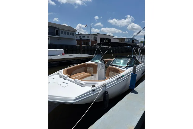 The Image of 2025 NauticStar 223 DC Deck boat docked under a clear blue sky. - 0