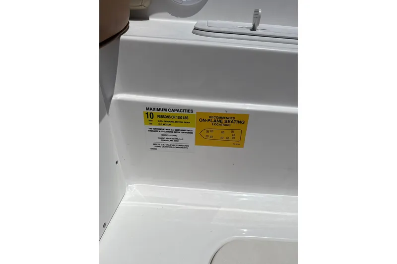 Slide: The Image of 2025 NauticStar 223 DC Deck boat capacity label, seating for 10 people or 1350 lbs. - 9