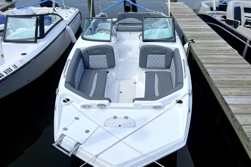 Slide: The Image of 2025 NauticStar 223 DC boat docked, featuring sleek design and comfortable seating. - 1