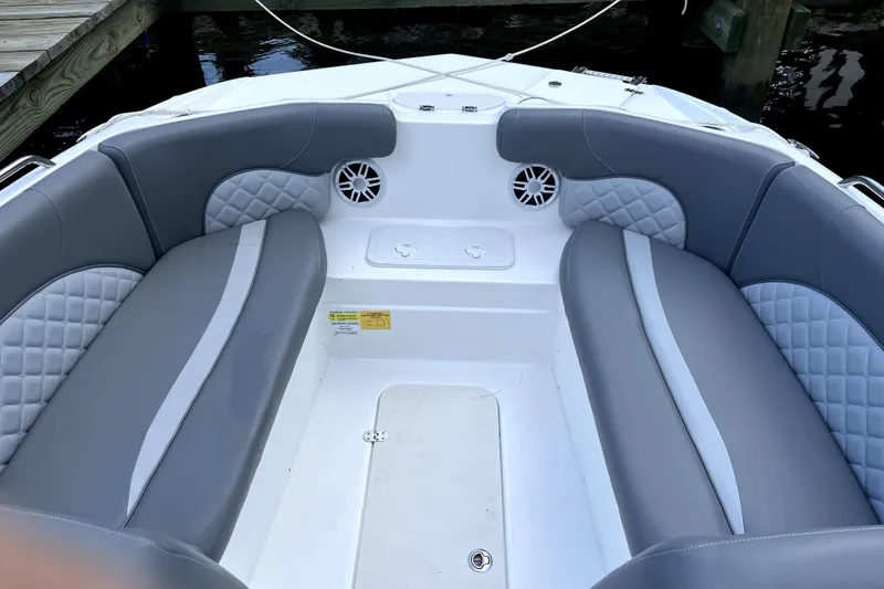 Slide: The Image of 2025 NauticStar 223 DC boat interior with gray cushioned seating and speakers. - 7