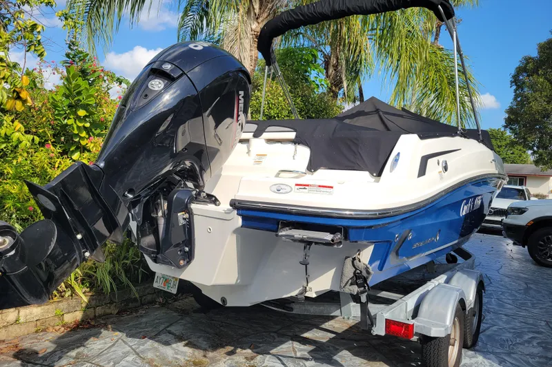Slide: The Image of 2023 Bayliner VR6 Bowrider OB on trailer, surrounded by lush greenery. - 8
