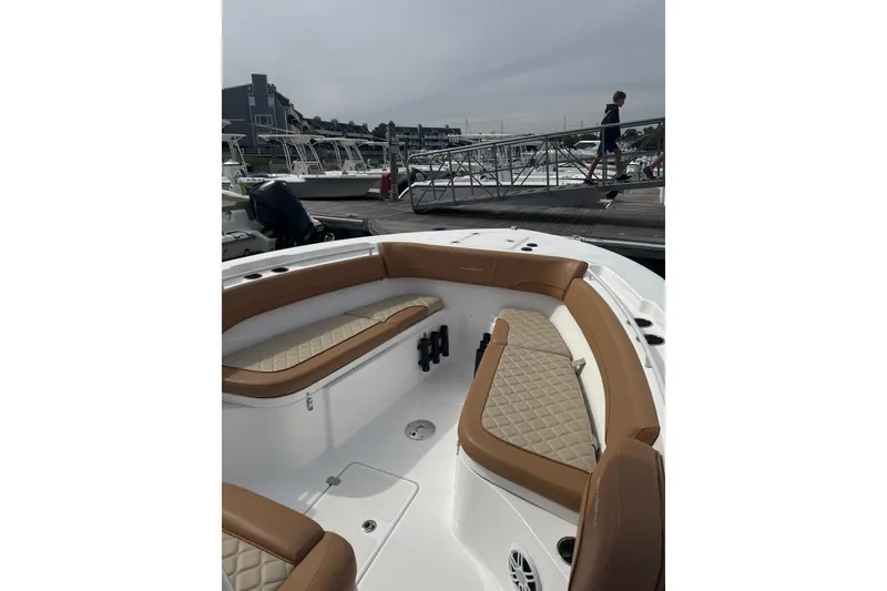 Slide: The Image of 2025 NauticStar 292 Legacy boat with tan seating at a marina. - 5