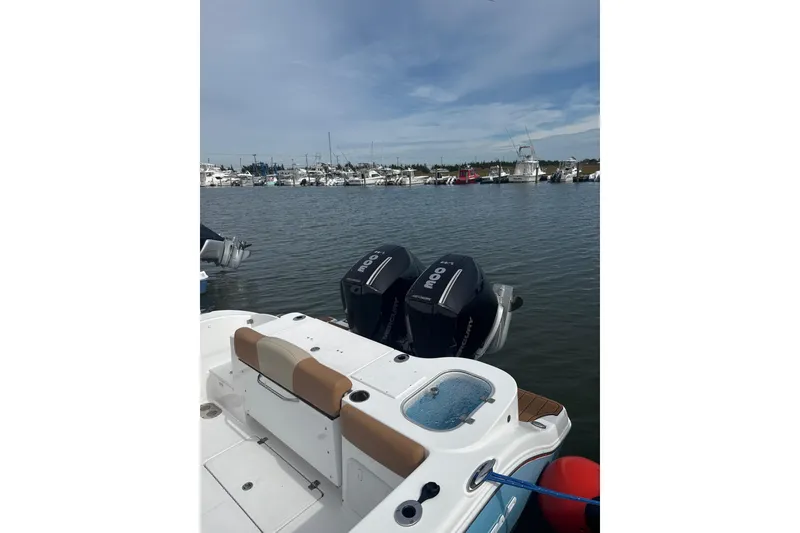 Slide: The Image of 2025 NauticStar 292 Legacy boat with twin Mercury engines docked in a marina. - 7