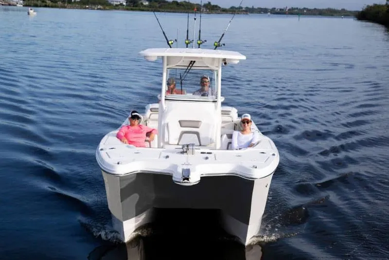 Slide: The Image of Manufacturer Provided Image: 2026 World Cat 295 CC boat cruising on a calm lake with passengers relaxing. - 2