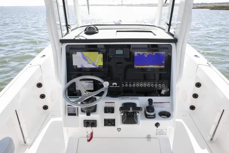 Slide: The Image of Manufacturer Provided Image: 2026 World Cat 295 CC boat dashboard with navigation screens and steering wheel on open water. - 6